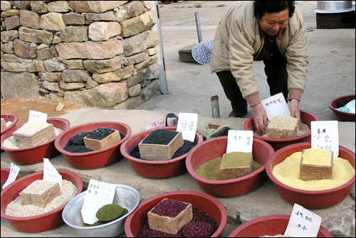 우리네 인심은 됫박을 깎아선 안되는 것으로 알고 있다며 "틈날때마다 이렇게 수북하게 쌓아 놓아야 보기에도 좋고 담아주기도 편하다"면서 흘러내린 잡곡을 다시 됫박에 올려놓고 있다 